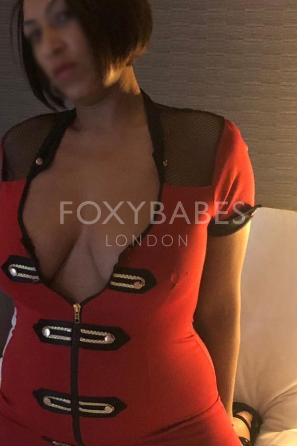 sexy brunette escort in red top revealing cleavage 