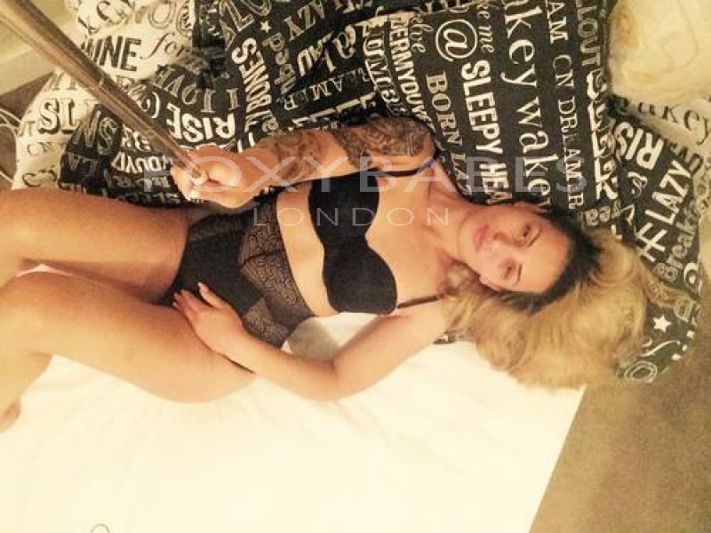 sexy babe lying on bed taking selfie with selfie stick 
