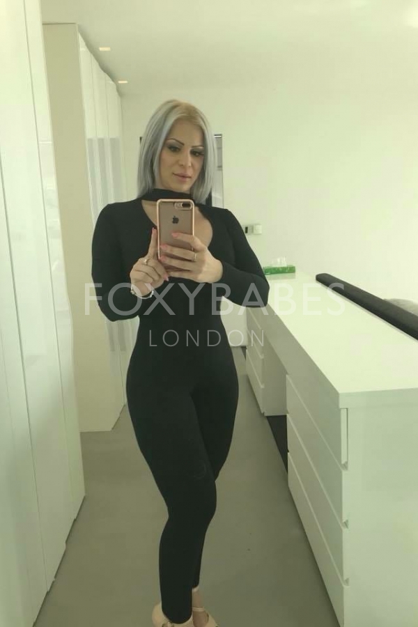 Jazmin in black jumpsuit taking selfie 